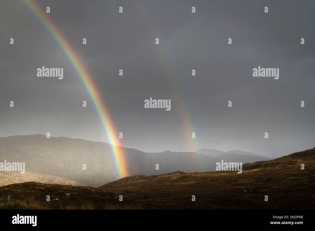 A wet, autumnal HDR image of a double rainbow over the Sutherland landscape near Unapool, in the Scottish Highlands. 26 October 2022 Stock Photo