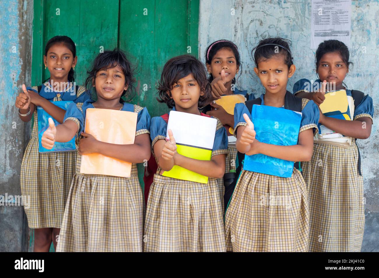 ' Group of School Girls  holding books showing thumps up Stock Photo