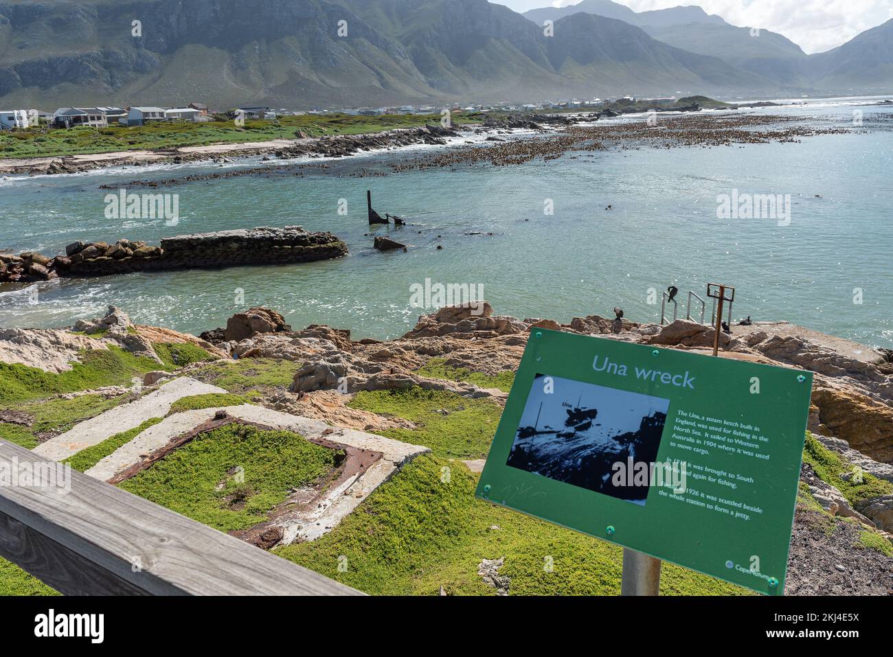 Bettys Bay, South Africa - Sep 20, 2022: Information board with part of the Una shipwreck visible at Stony Point Nature Reserve in Bettys Bay. Stock Photo