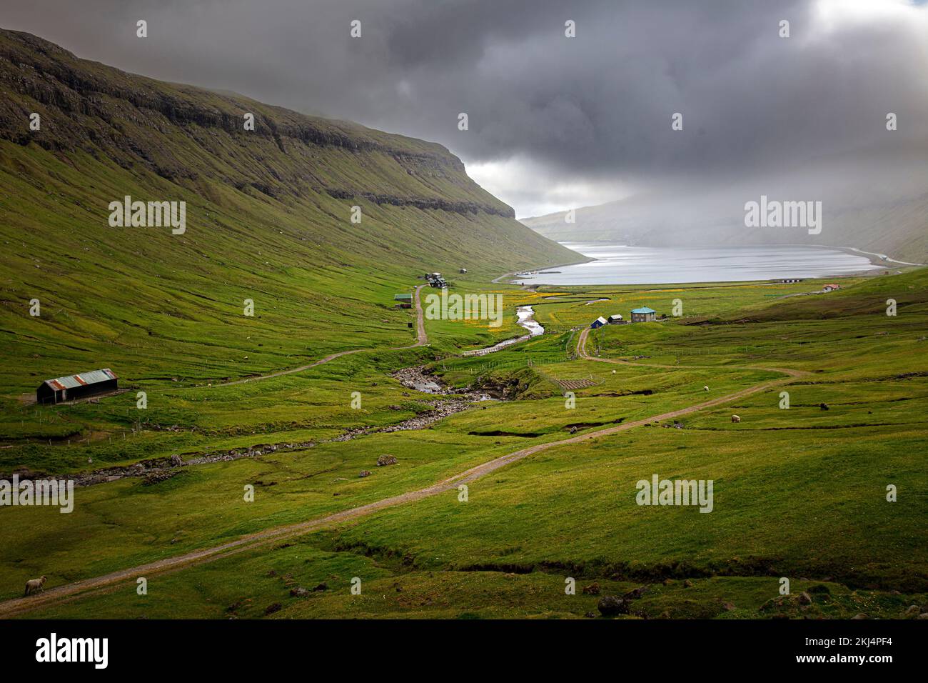 green valley with cloudy sky on faroe islands Stock Photo