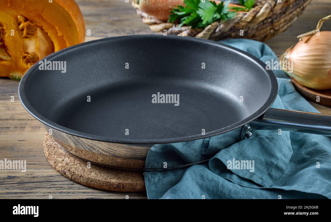 empty clean frying pan on wooden kitchen table Stock Photo