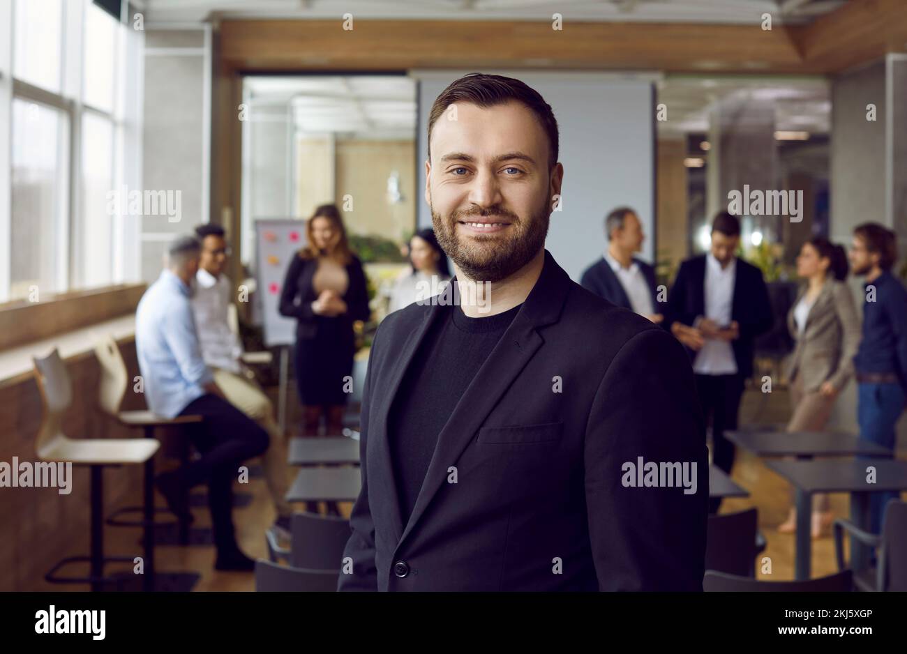 Happy business coach standing in office after professional corporate training class Stock Photo