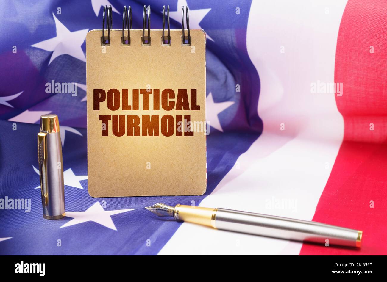 Business concept. Against the background of the American flag is a notepad with the inscription - political turmoil Stock Photo