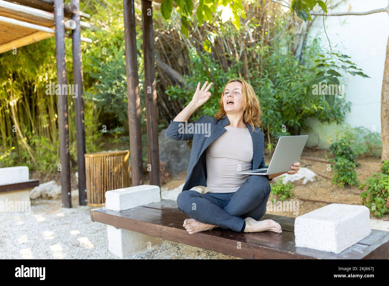 A beautiful freelancer woman works at the park using a computer. Stock Photo