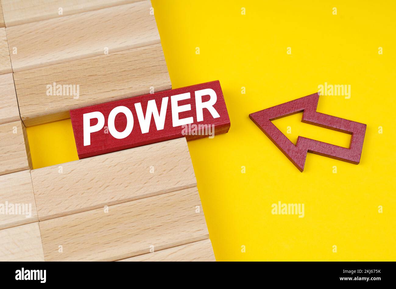 Business concept. On a yellow surface are wooden blocks and an arrow pointing to a block with the inscription - POWER Stock Photo