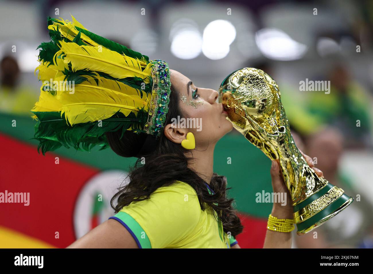 Lusail, Qatar. 24th Nov, 2022. A fan kisses a replica of the World Cup trophy before the Group G match between Brazil and Serbia at the 2022 FIFA World Cup at Lusail Stadium in Lusail, Qatar, Nov. 24, 2022. Credit: Xu Zijian/Xinhua/Alamy Live News Stock Photo