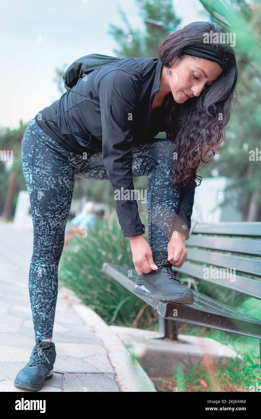 Sneakers. close up of a woman tying shoelaces. Women's sneaker ready for outdoor running in the park or forest. Stock Photo