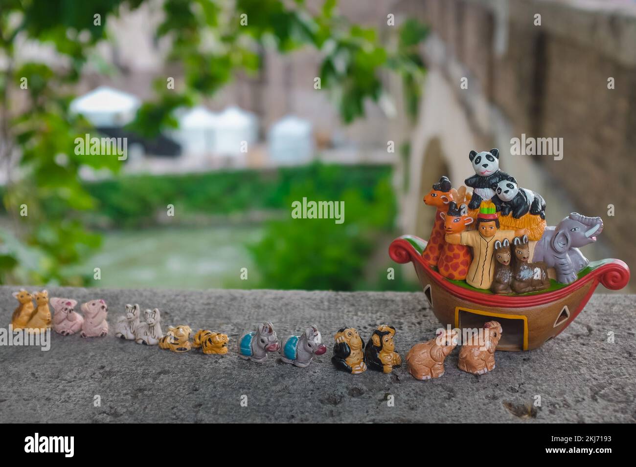 Small ceramic figurines reenact animals lining up in pairs to enter Noah's Ark. Cute, child-friendly Bible story depiction. Genesis flood narrative. Stock Photo