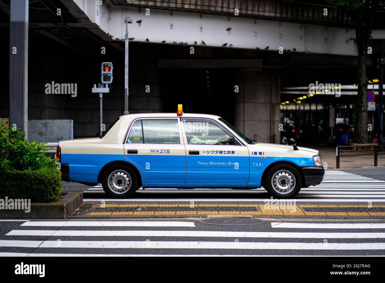 A blue and white Mercedes taxi car parked on the side of an empty street in Tokyo, Japan Stock Photo