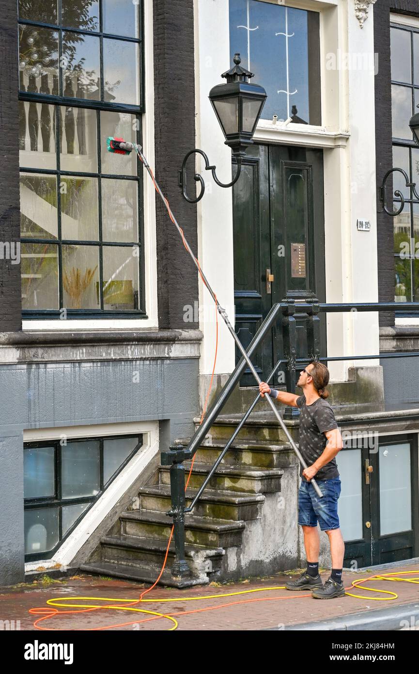 Amsterdam, Netherlands August 2022 Person cleaning the windows of a