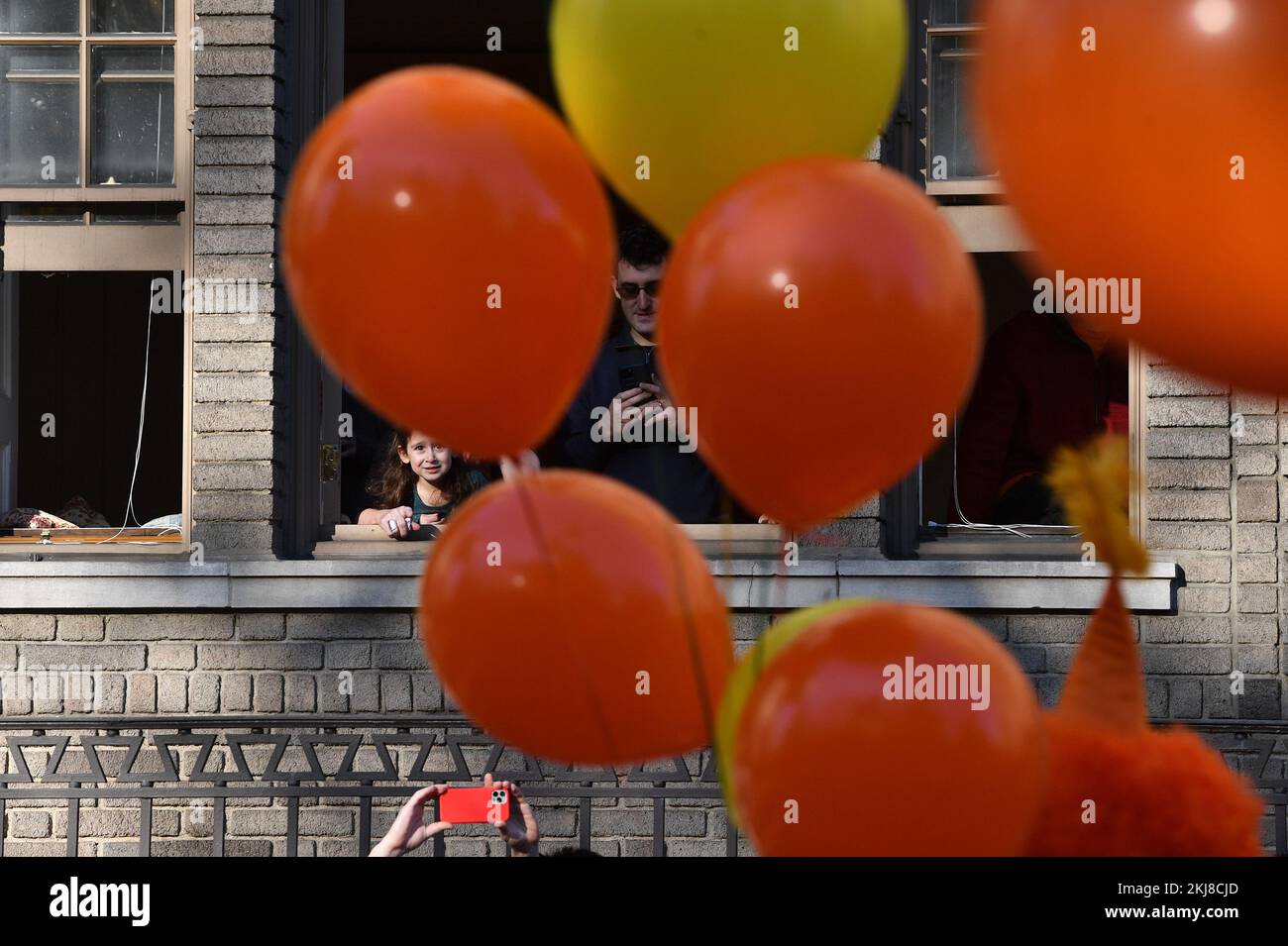 New York, USA. 24th Nov, 2022. A young girl and her family look out the window on Central Park West during the 96th Annual Macy's Thanksgiving Day Parade in New York, NY, November 24, 2022. (Photo by Anthony Behar/Sipa USA) Credit: Sipa USA/Alamy Live News Stock Photo
