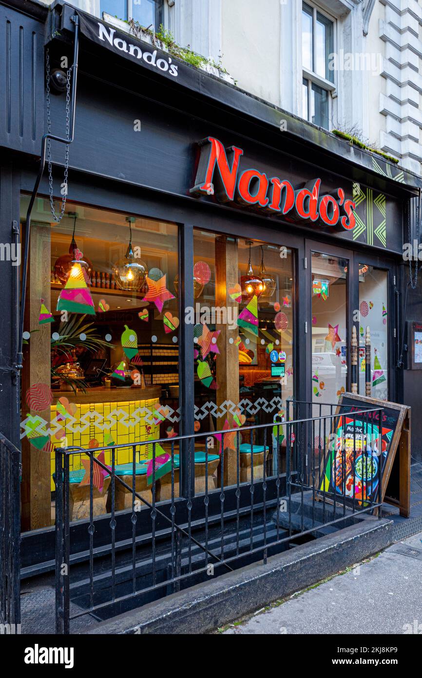 Nandos Restaurant London - Nandos Restaurant on Goodge St, Fitzrovia, Central London. Nandos, a restaurant chain, was founded in 1987 in South Africa. Stock Photo