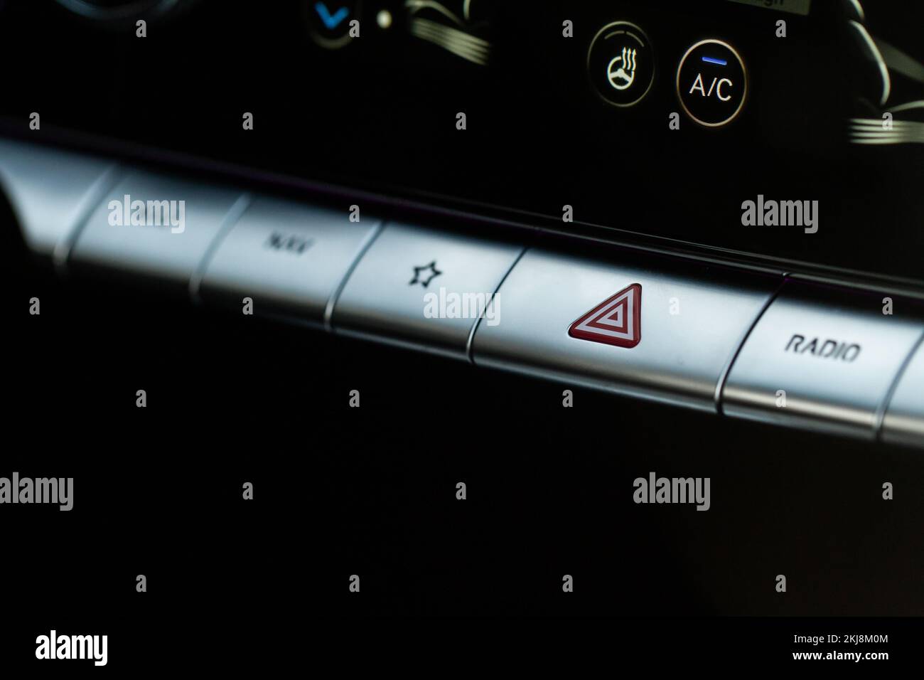 Red triangle hazard light button on car dashboard. Car media buttons