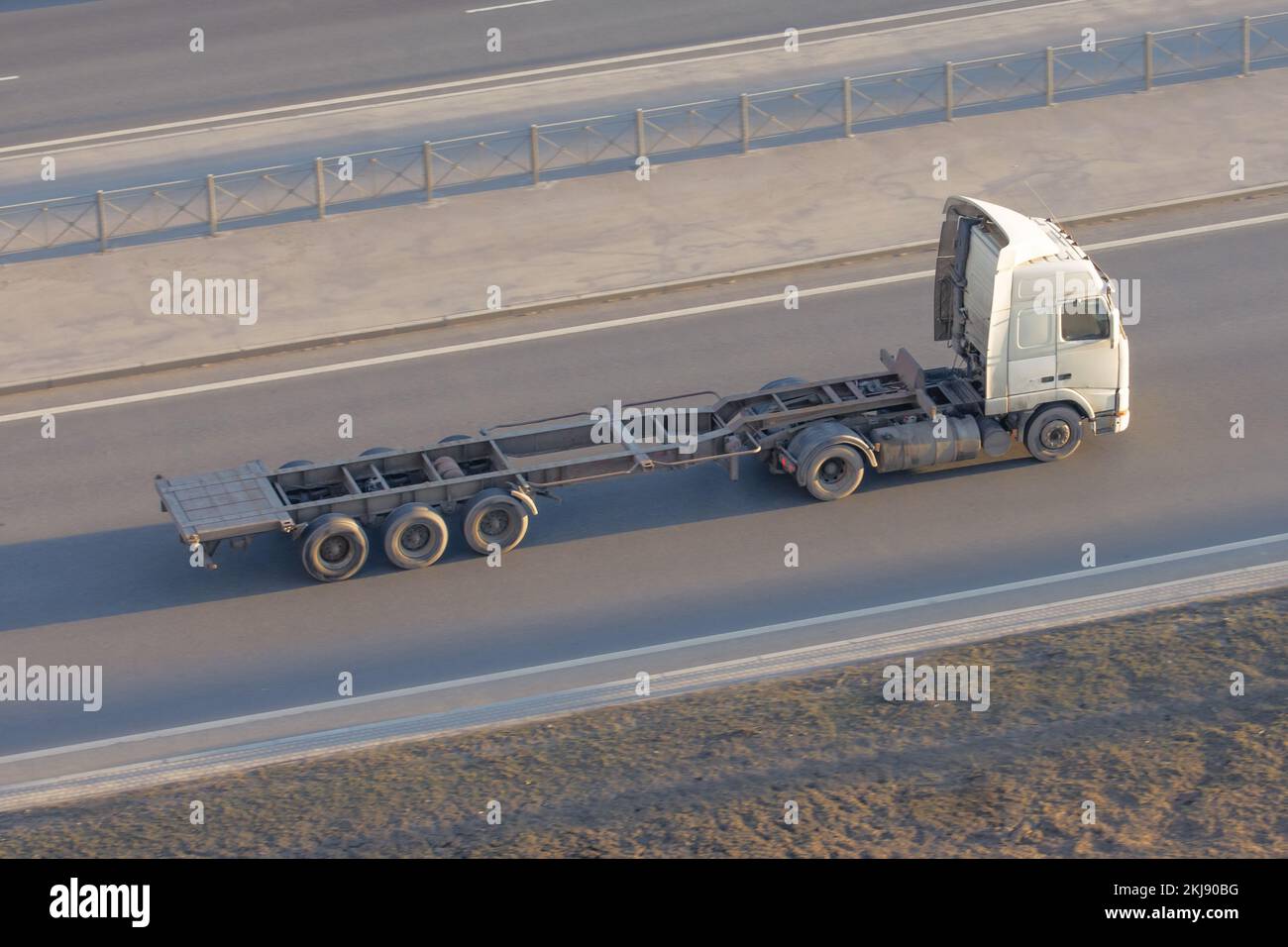 Truck with an empty long trailer without cargo, driving on the highway, top above view Stock Photo