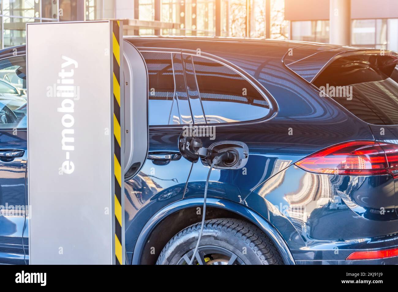 Charging the machine, compartment door is open, the electric plug under voltage restores the battery charge. Refueling for electric cars e-mobility Stock Photo