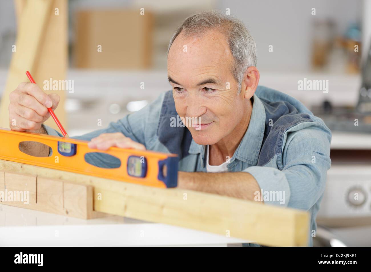 senior constructor holding a ruler on build background Stock Photo - Alamy