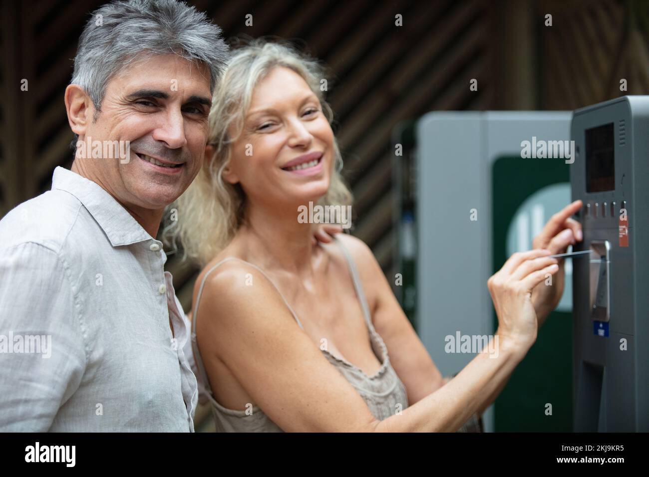 middle aged couple standing at a pay station Stock Photo