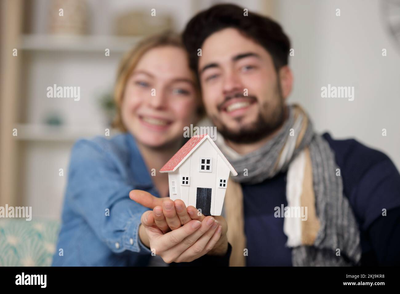 young happy couple holding small model house Stock Photo - Alamy