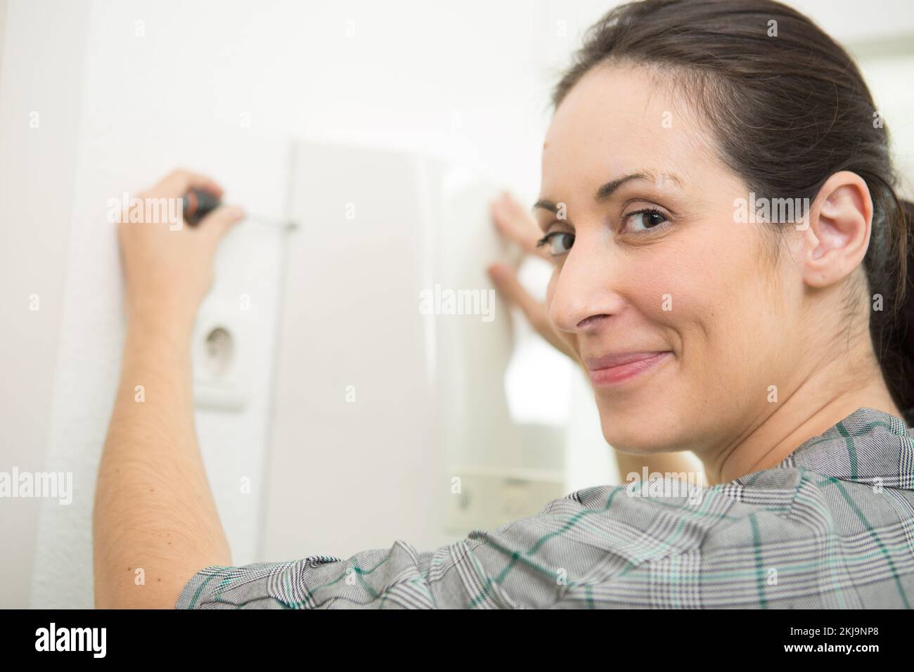 happy woman repairing a broken dryer Stock Photo Alamy