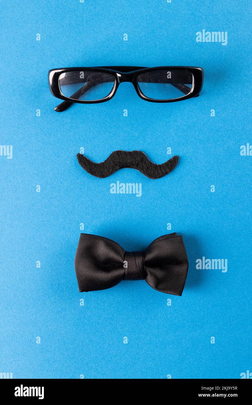 Composition of fake moustache with glasses and bow tie on blue ...