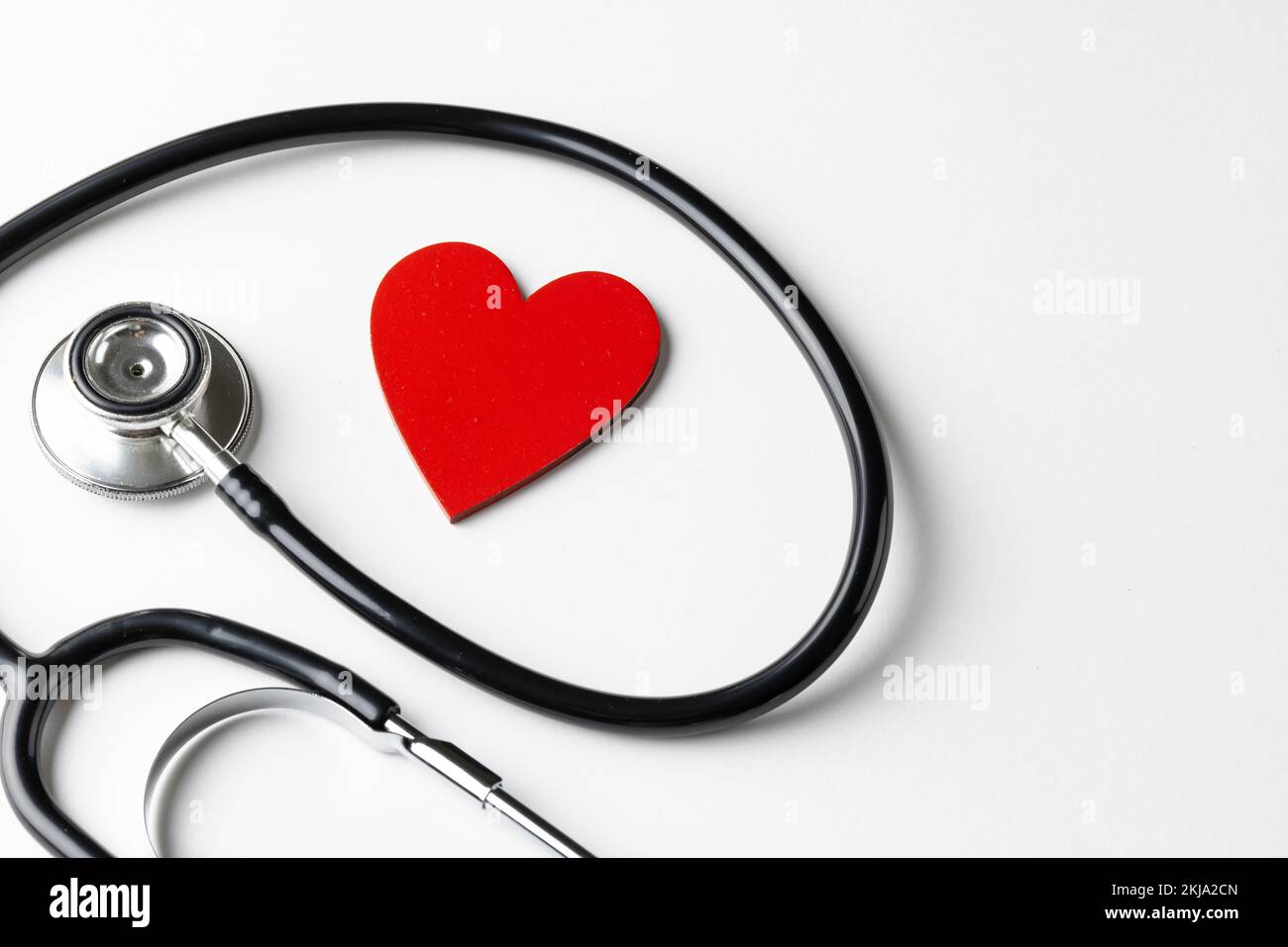 Composition of stethoscope and red heart on white background with copy ...