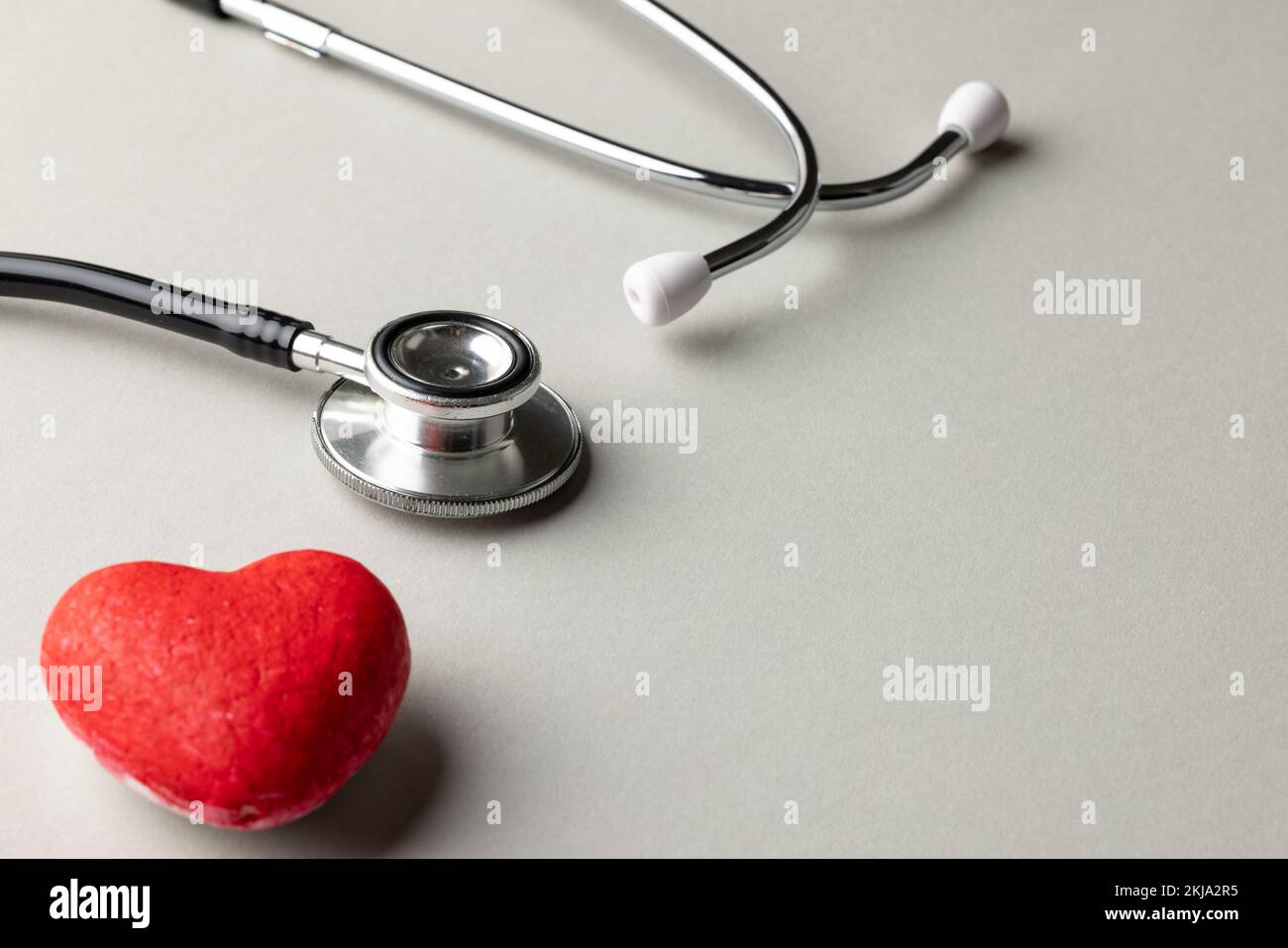 Composition of stethoscope and red heart on grey background with copy space Stock Photo