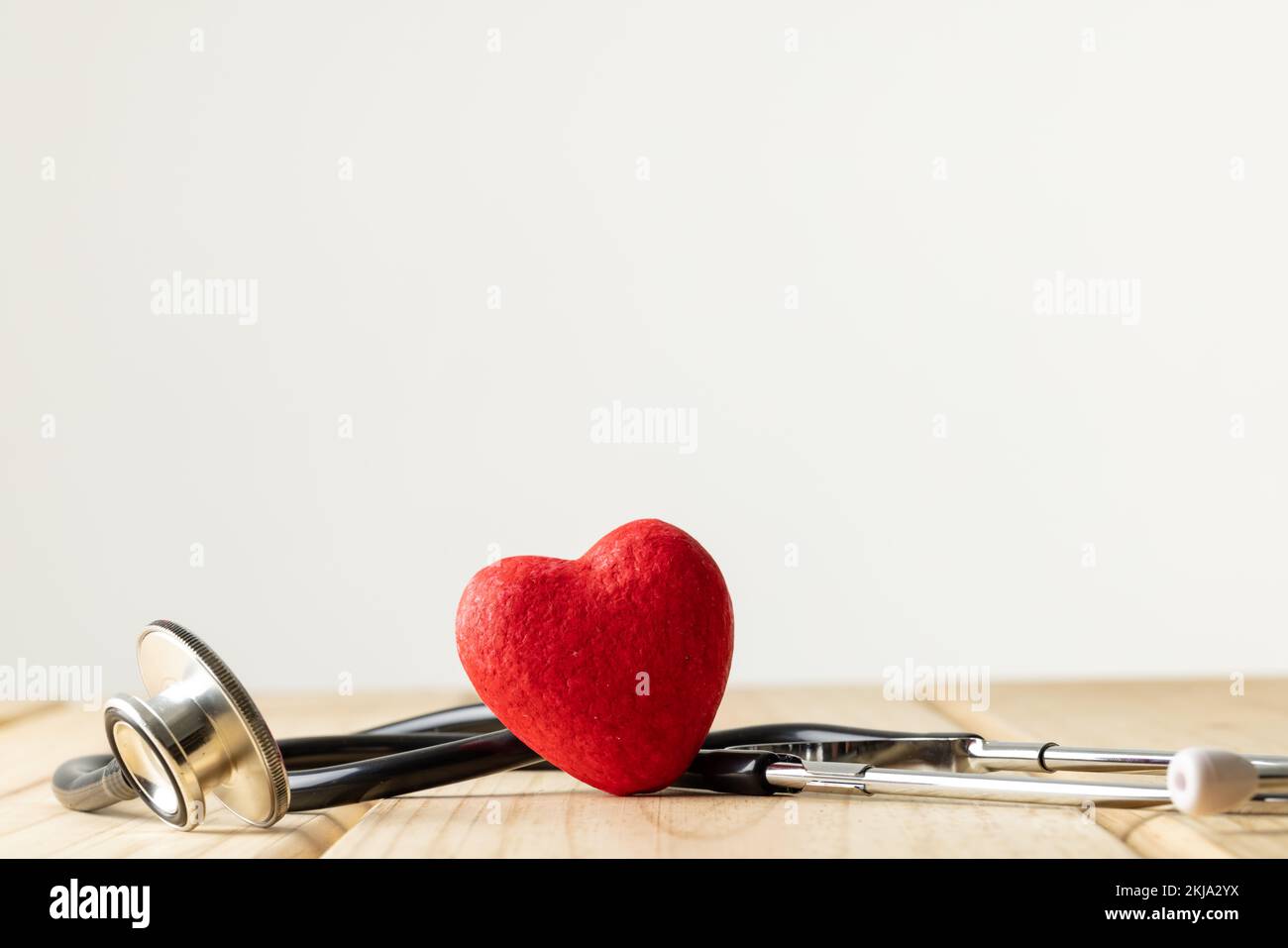 Composition of stethoscope and red heart on white background with copy ...