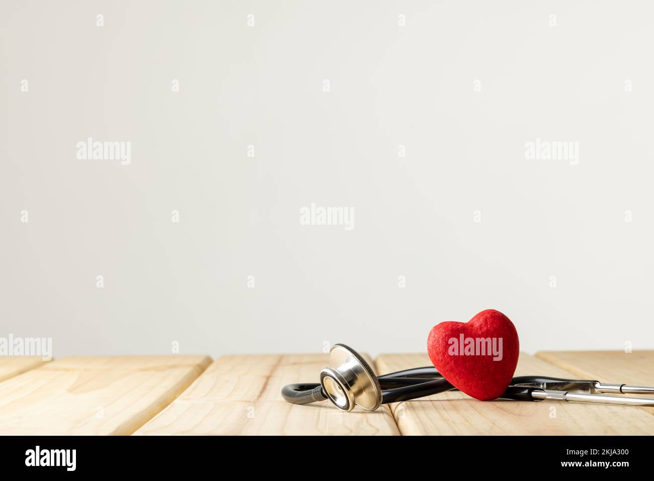 Composition of stethoscope and red heart on white background with copy ...