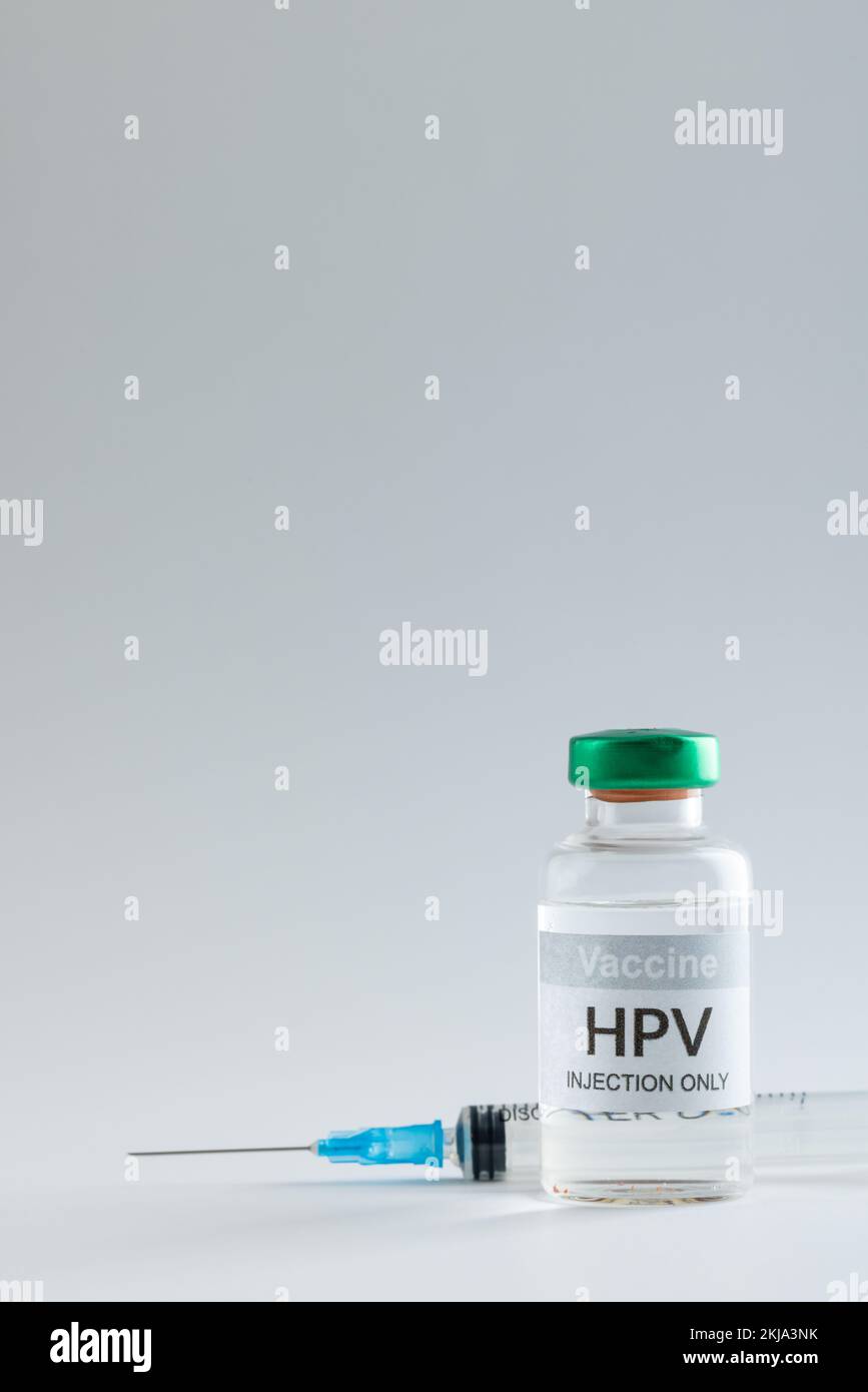 Vertical composition of hpv vaccine vial and syringe on grey background with copy space Stock Photo