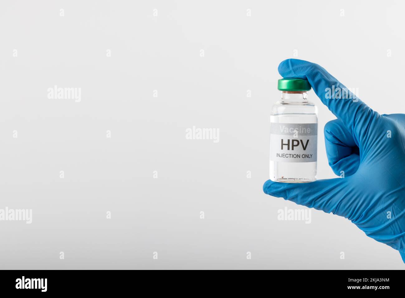 Composition of gloved hand holding hpv vaccine vial on white background