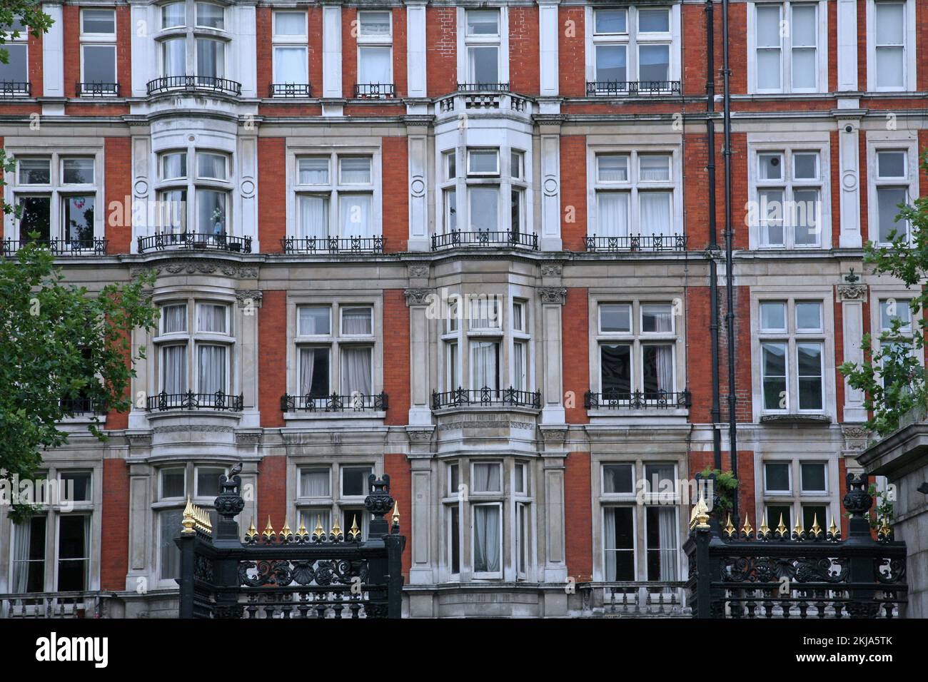 Elegant apartment building, red brick with stone trim around bay windows, Bloomsbury area of London Stock Photo