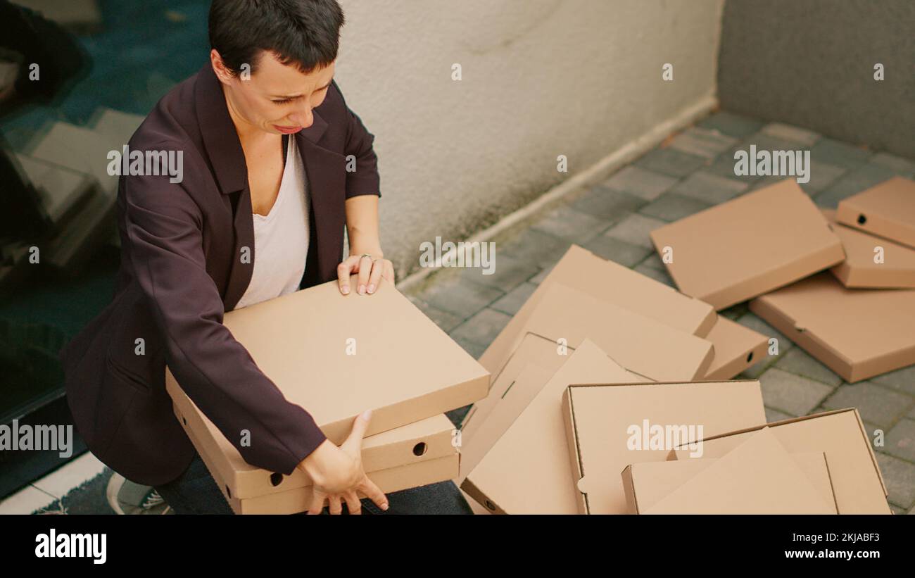 Sad customer crying after dropped pizza boxes, clumsy courier dropping