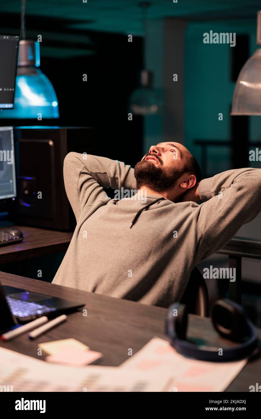 Happy IT programmer relaxing on office chair, finishing database cloud