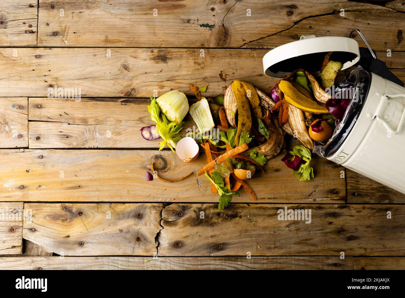 Organic fruit and vegetable food waste spilling from open kitchen composting bin Stock Photo
