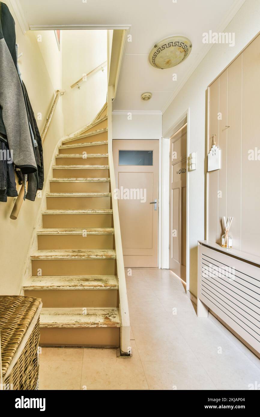 Light narrow hallway with door and radiator in white walls and glowing ...