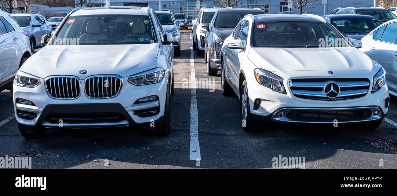 Two separate vehicles, a white BMW and a white Mercedes Benz for sale