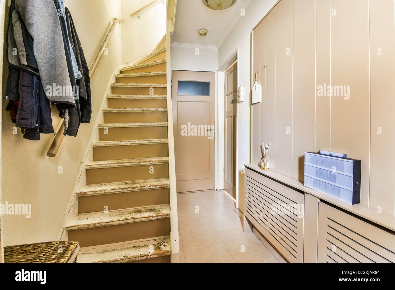 Light narrow hallway with door and radiator in white walls and glowing ...