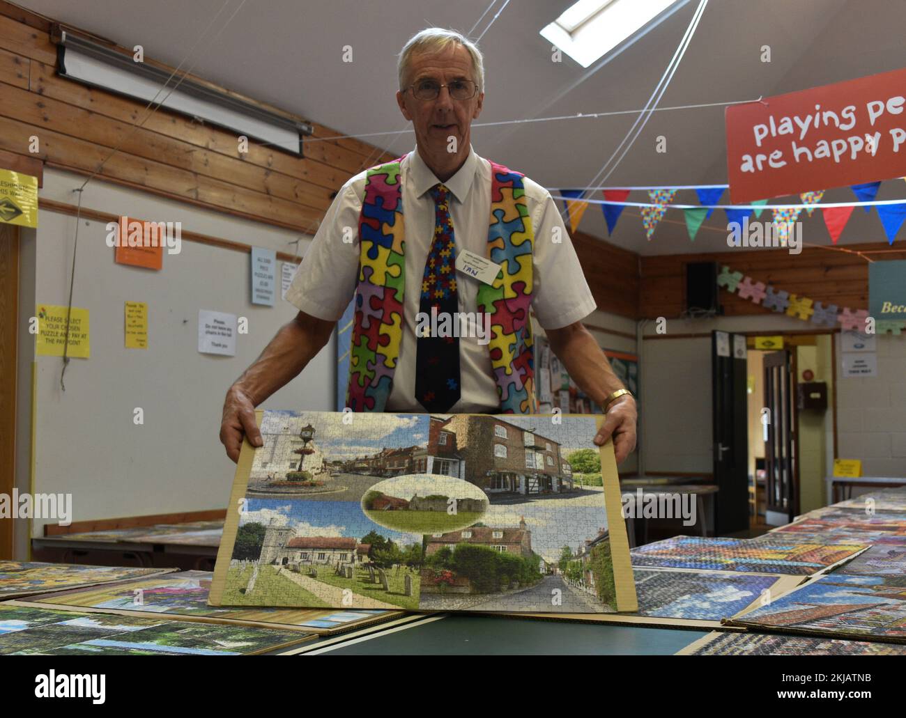 Volunteer Holding A Complete Jigsaw Puzzle On A Piece Of Cardboard At