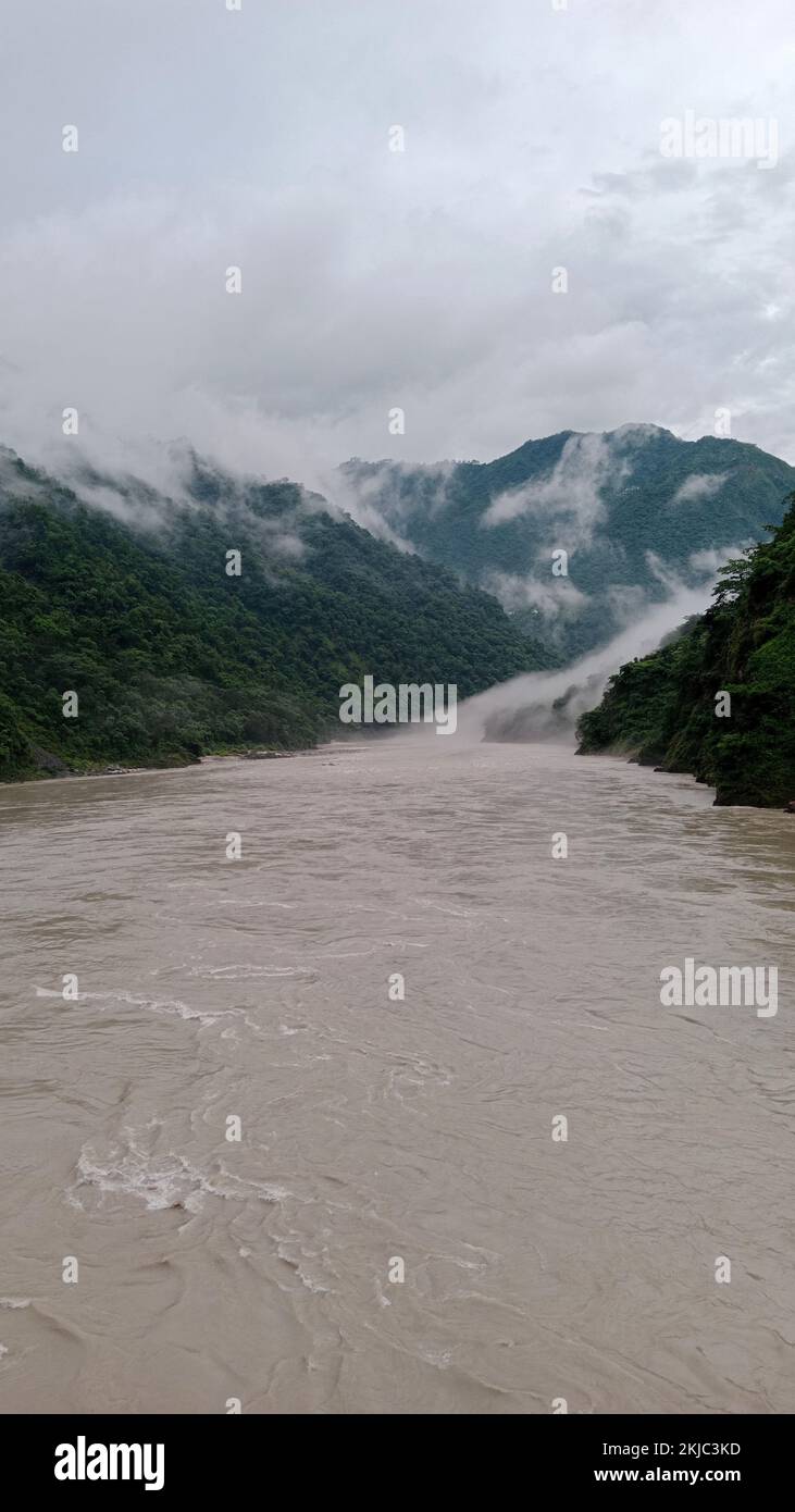 A vertical shot of the river in the mountains on a foggy day Stock ...