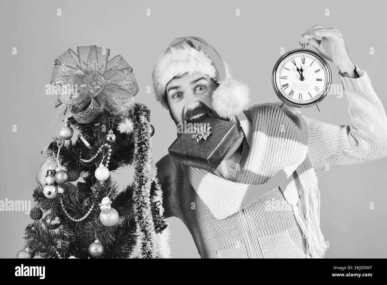 Guy in red hat with blue gift box in teeth Stock Photo Alamy