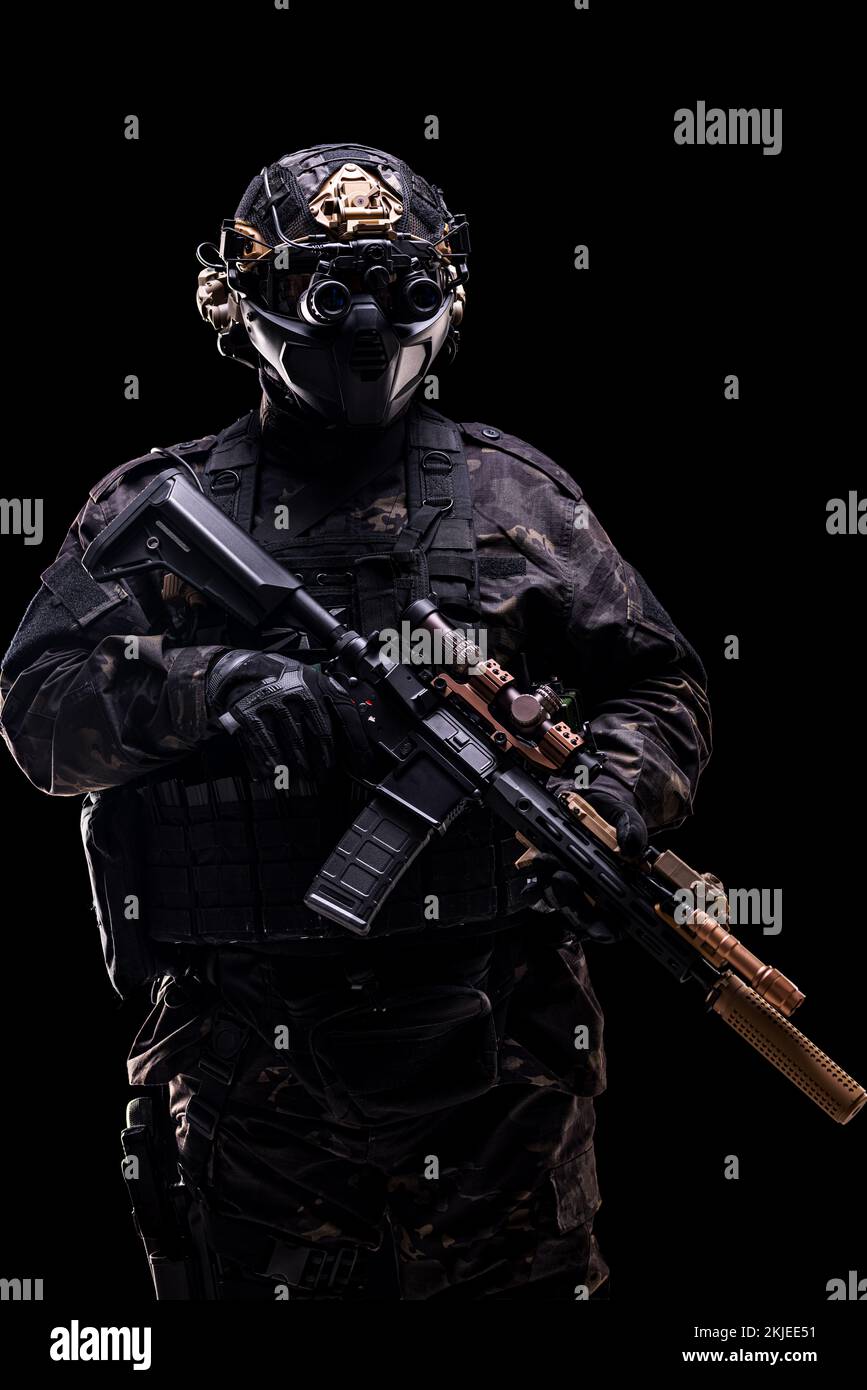 full body fully equipped soldier in tactical clothing and gear isolated on black background. Stock Photo