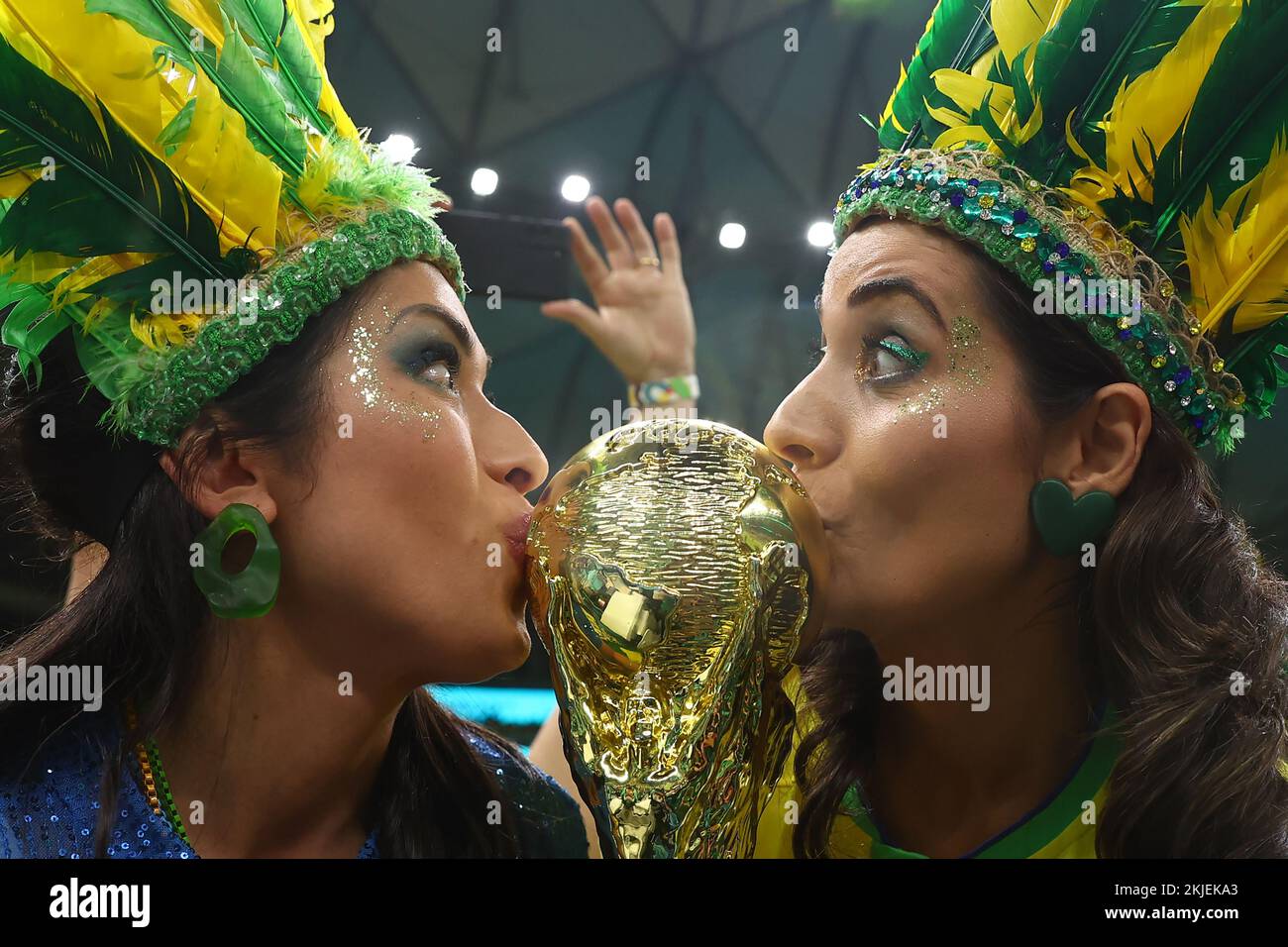 Doha, Qatar. 24th Nov, 2022. Brazil fans kiss a replica World Cup trophy during the 2022 FIFA World Cup Group G match at Lusail Stadium in Doha, Qatar on November 24, 2022. Photo by Chris Brunskill/UPI Credit: UPI/Alamy Live News Stock Photo