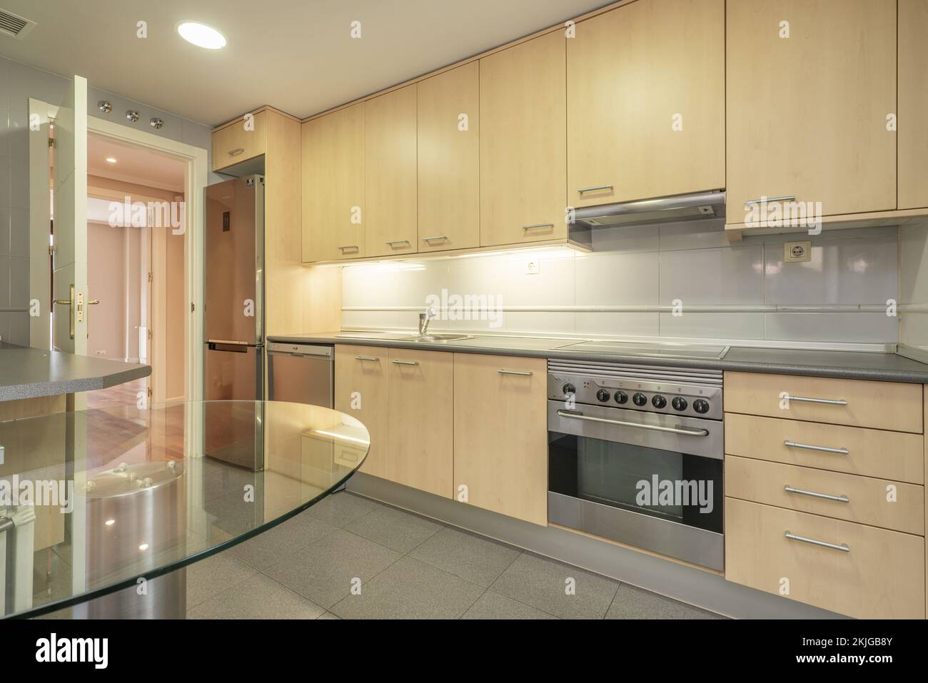 Kjgb Wall of a kitchen covered with base and wall units made of beech wood ...