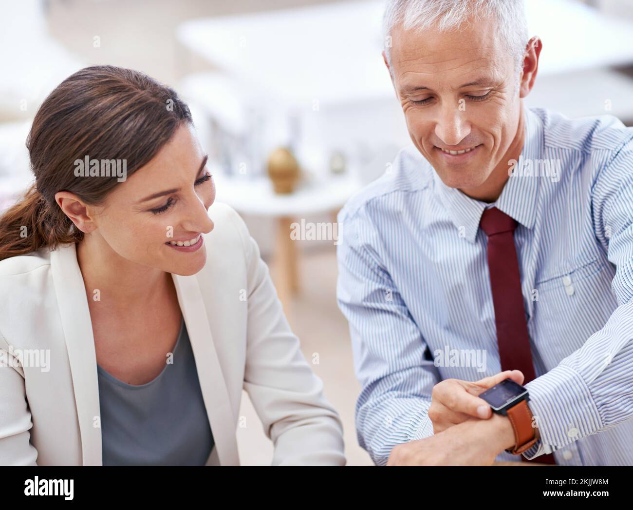 The latest technology... on my wrist. a businessman showing off his new watch to a coworker in the office. Stock Photo