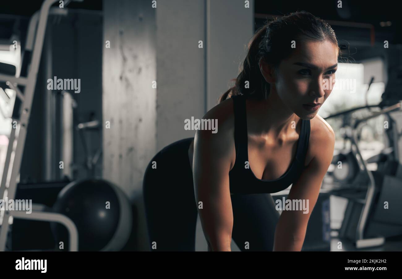 Close-up young woman lifts single kettlebell in the gym. Stock Photo