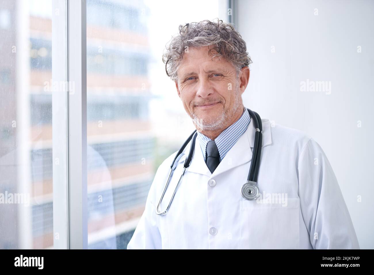 Smiling mature doctor standing hi-res stock photography and images - Alamy