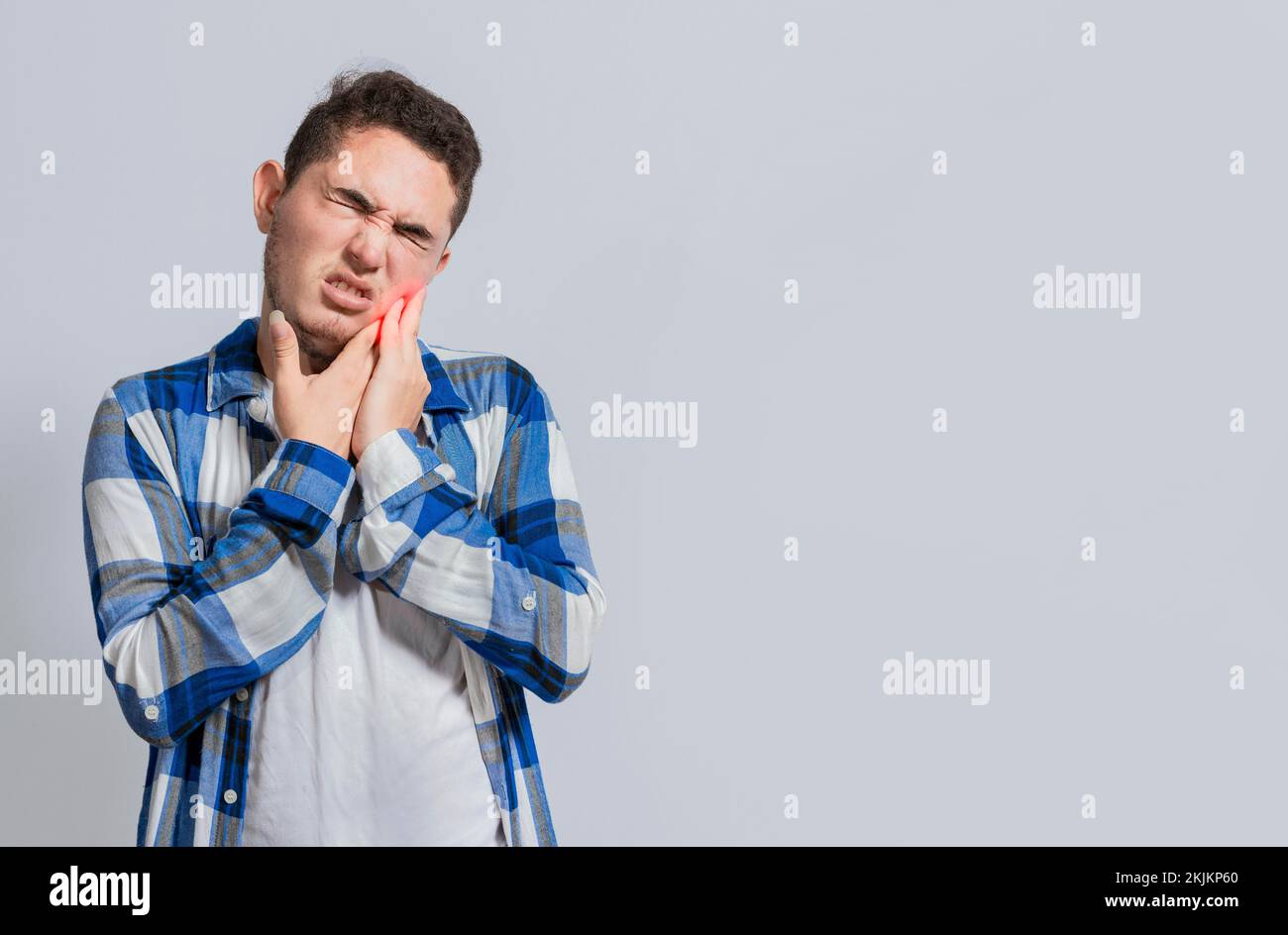 Man suffering with toothache or pulpitis. Concept of people suffering from toothache, Young man with sensitivity and toothache isolated. Tooth pain an Stock Photo