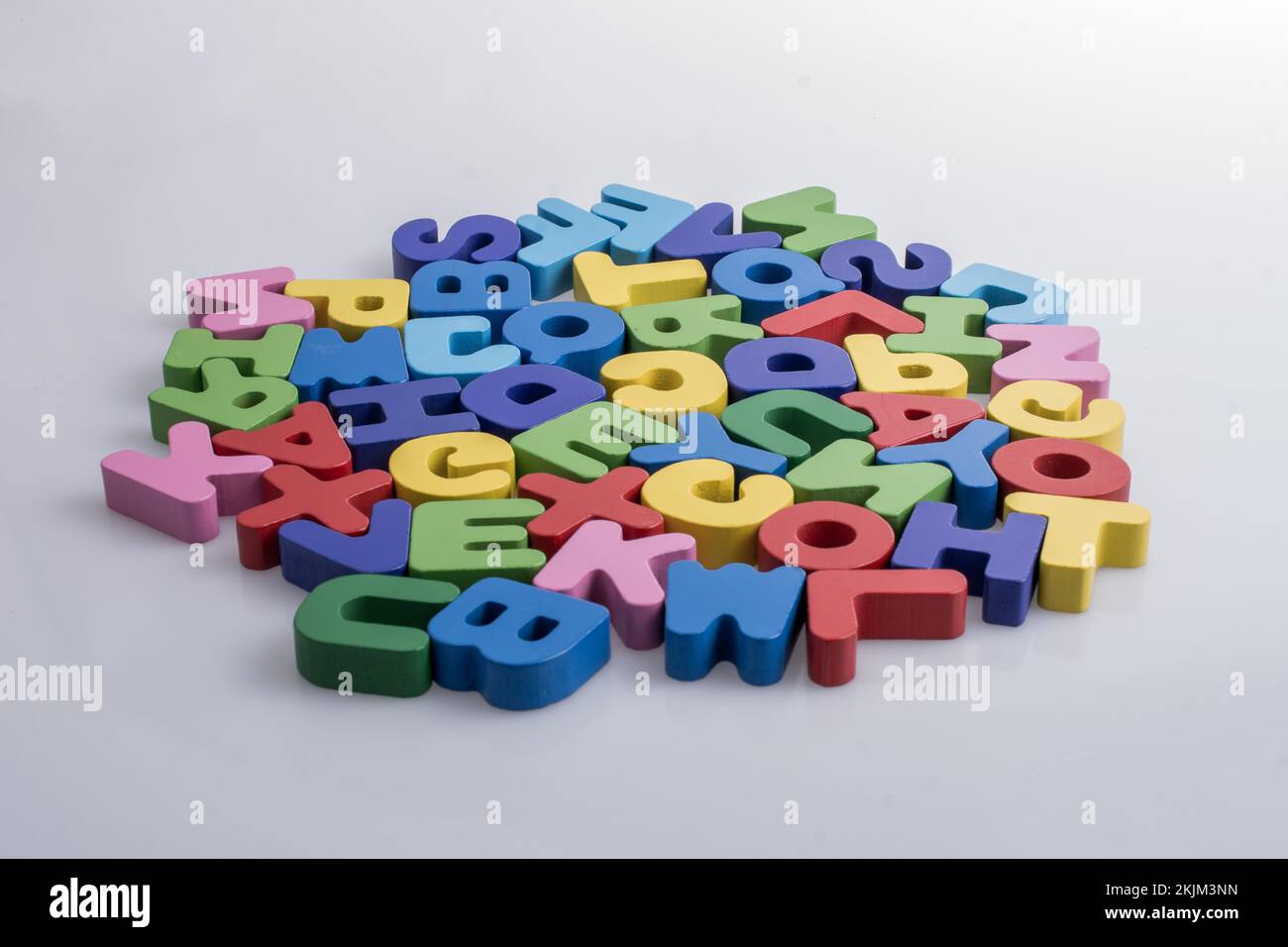 Colorful alphabet letter blocks scattered randomly on white background