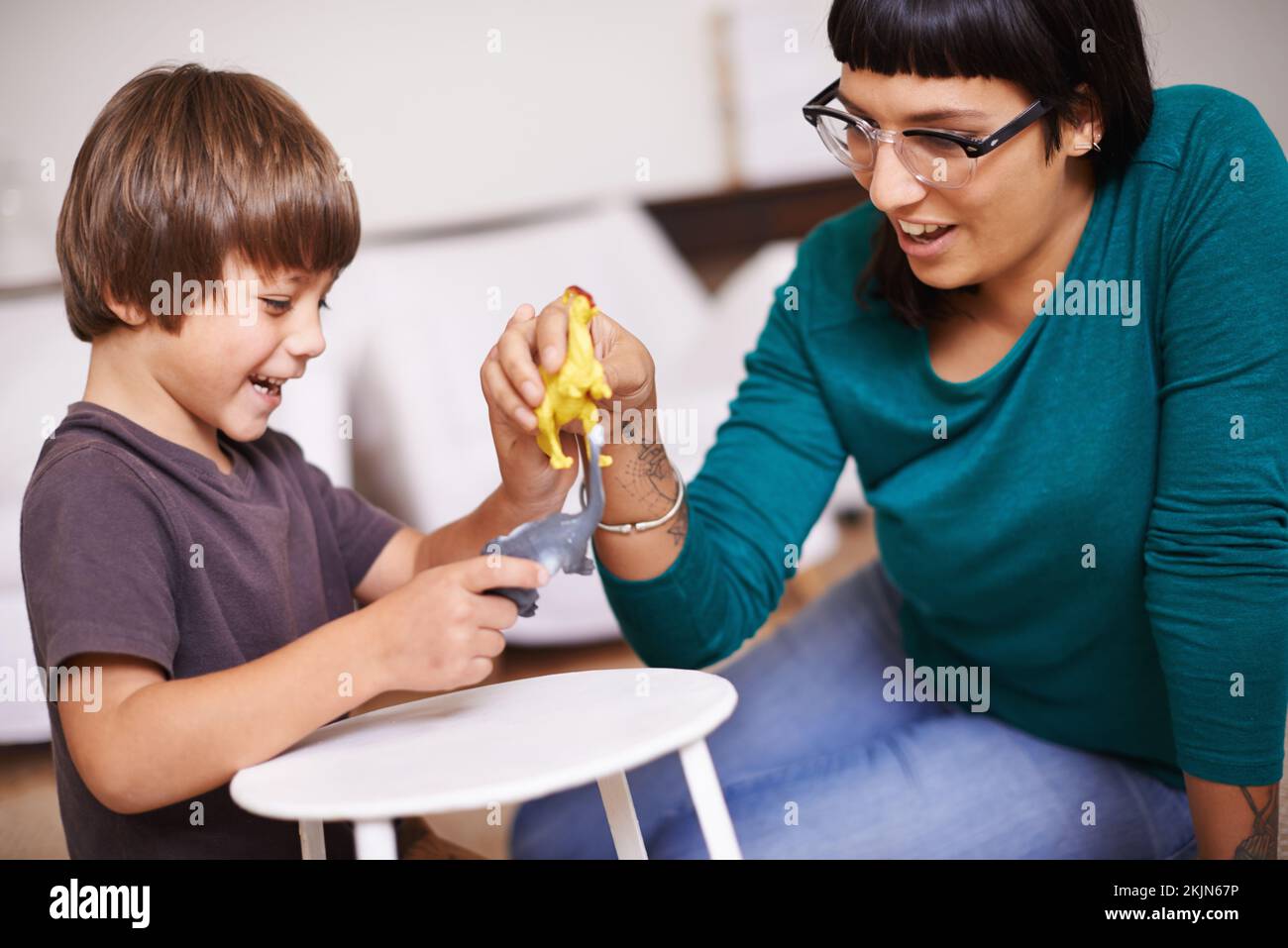 Communicating with each other using dinosaurs. a mother and her son playing with toy dinosaurs. Stock Photo