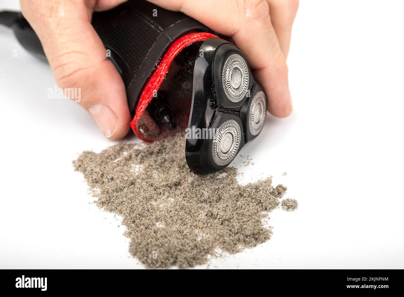 Electric shaver with three open shaving heads and shavings Stock Photo